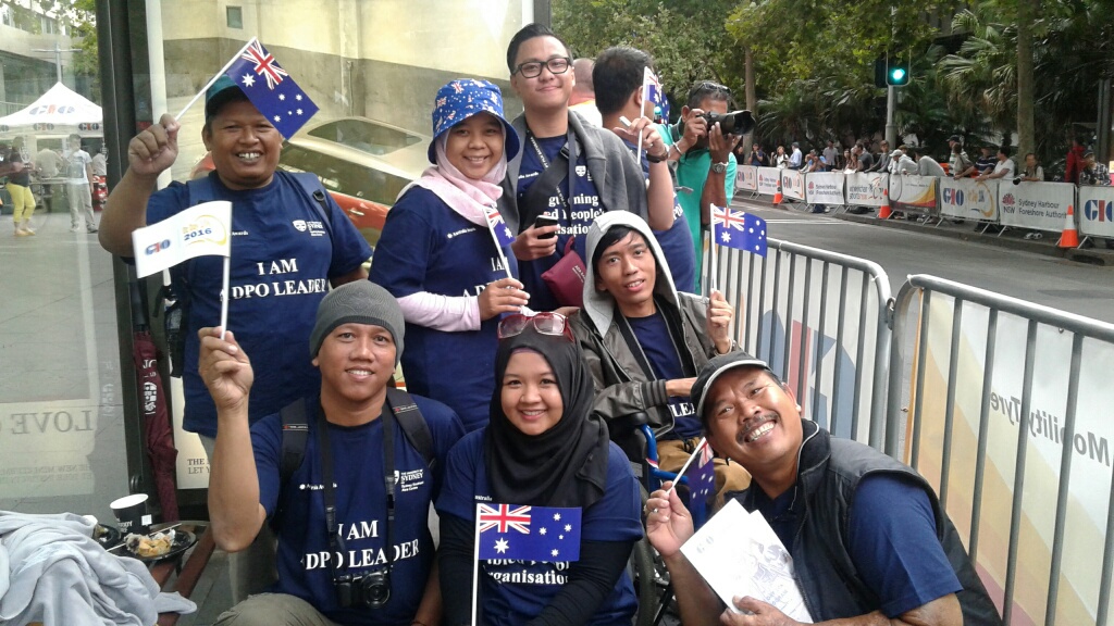 A group of people holding small Australian flag on the pedestrian